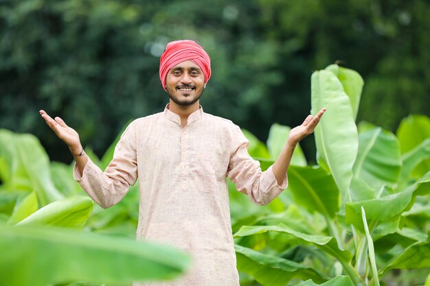 Jovem agricultor indiano no campo de agricultura de banana verde.