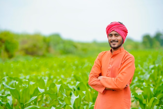 Jovem agricultor indiano no campo de milho.