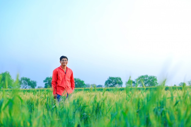 Jovem agricultor indiano no campo de trigo