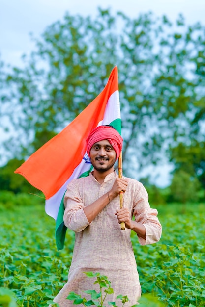 Jovem agricultor indiano segurando bandeira indiana em campo de agricultura