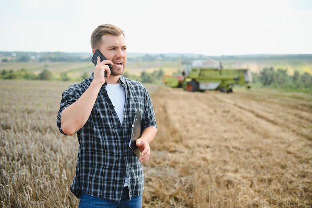 Jovem agricultor no campo de trigo durante a colheita no verão