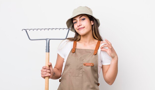 Jovem agricultora adulta com um conceito de ancinho