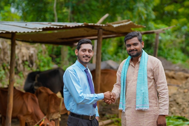 Jovem agrônomo ou oficial indiano visitando um fazendeiro em sua fazenda