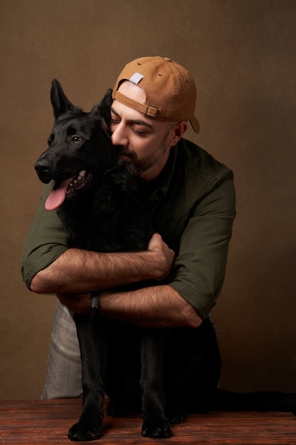 Foto jovem alegre abraçando seu cachorro, retrato dentro de casa