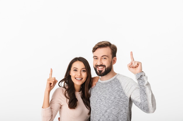 Foto jovem alegre apontando casal apaixonado.