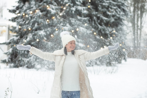 Jovem alegre brincando com neve na floresta