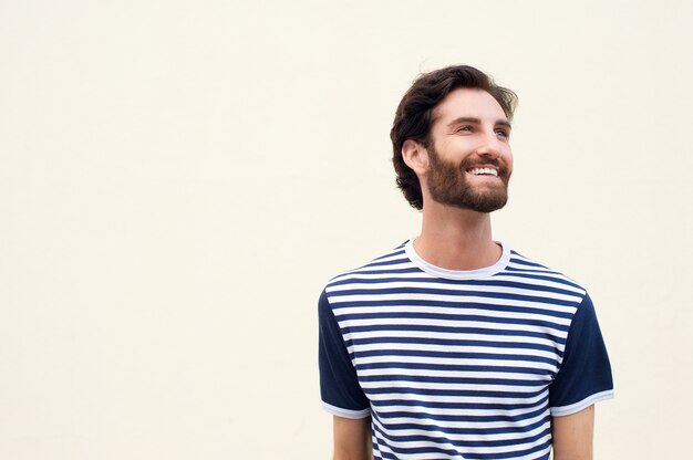 Jovem alegre com barba sorrindo sobre fundo branco