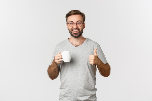 Jovem alegre com barba, usando óculos e camiseta cinza