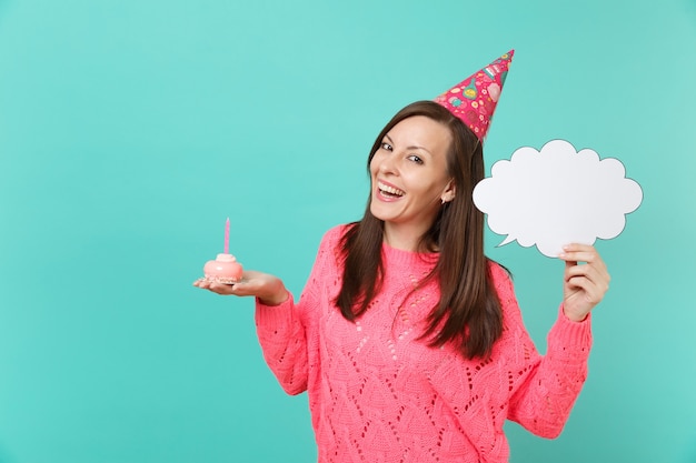 Jovem alegre com chapéu de aniversário segura na mão bolo com vela vazia em branco Diga nuvem, balão para conteúdo promocional isolado sobre fundo azul. Conceito de estilo de vida de pessoas. Simule o espaço da cópia.