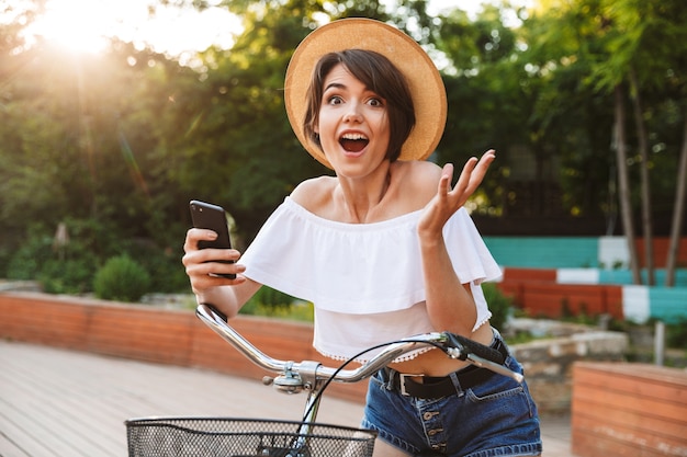 Jovem alegre com roupas de verão andando de bicicleta