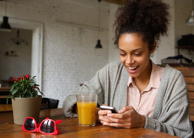 Jovem alegre digitando uma mensagem de texto no celular