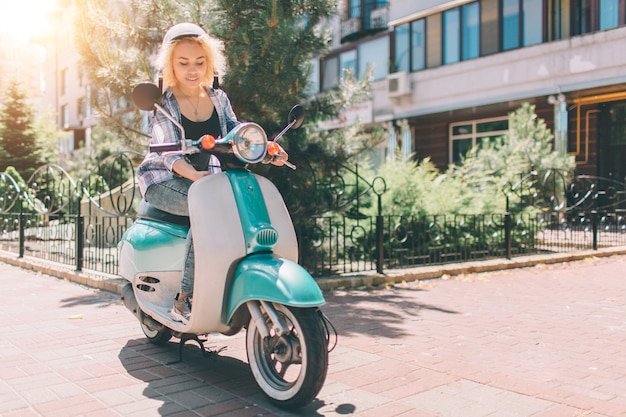 Jovem alegre dirigindo scooter na cidade