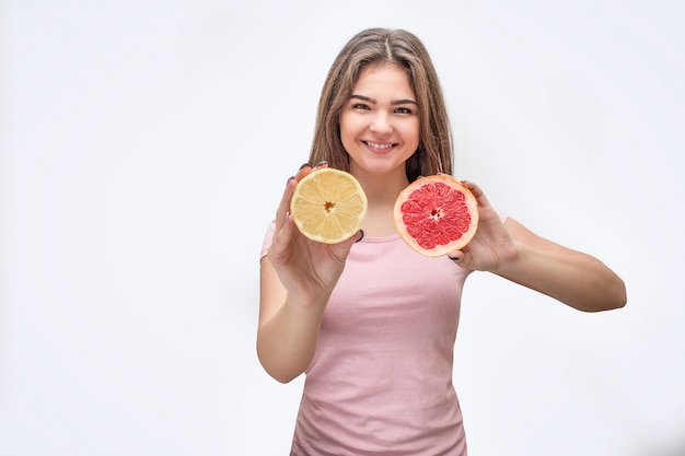 Jovem alegre e agradável segurar metade do limão e toranja nas mãos