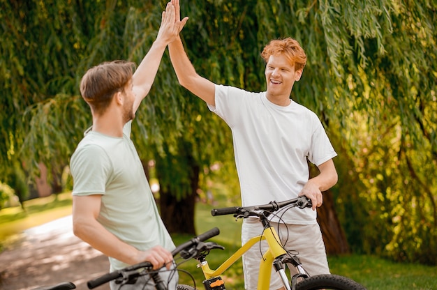 Jovem alegre e alegre cumprimentando seu amigo em um parque