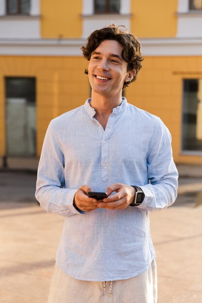 Foto jovem alegre e casual segurando um celular