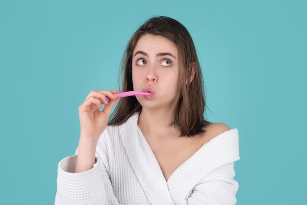 Jovem alegre escovando os dentes com escova de dentes durante os procedimentos de higiene matinal isolado backg