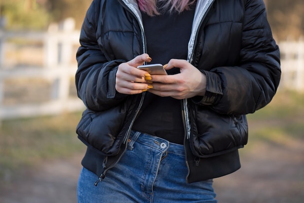 Foto jovem alegre escreve uma mensagem de texto com seu celular