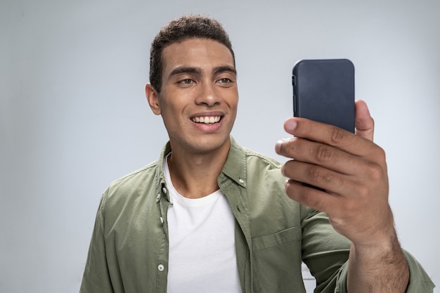 Foto jovem alegre olhando para a tela do smartphone