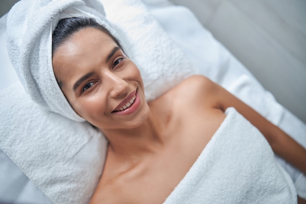 Jovem alegre relaxando em um salão de spa