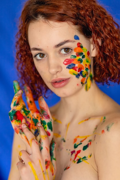 Foto jovem alegre ruiva suja de tinta colorida