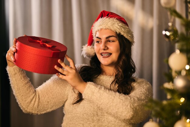 Jovem alegre segurando um presente de Natal