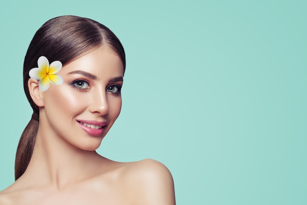 Jovem alegre sorrindo linda garota com maquiagem e flores no fundo com espaço de cópia