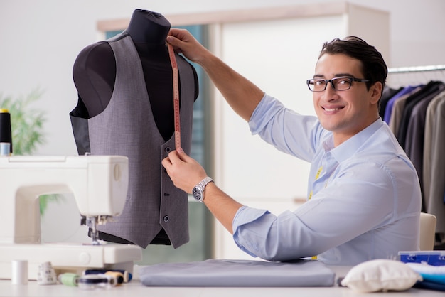 Foto jovem alfaiate trabalhando em roupas novas