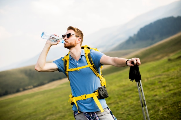 Jovem alpinista parou e beber água de uma garrafa