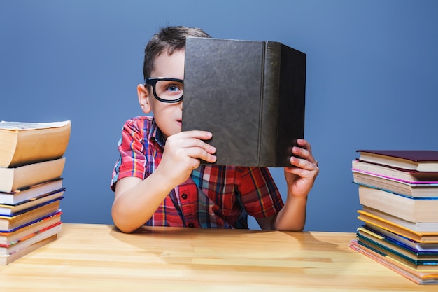 Jovem aluno de óculos, obtendo conhecimento de um livro didático. conceito de educação