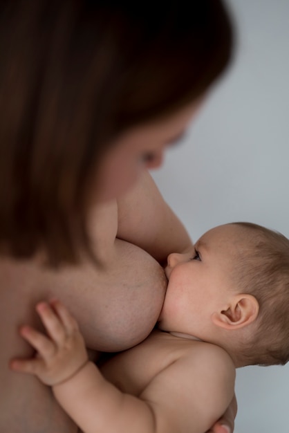 Foto jovem amamentando seu lindo bebê