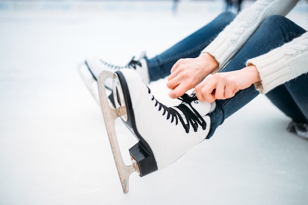 Jovem amarrando o cadarço em patins