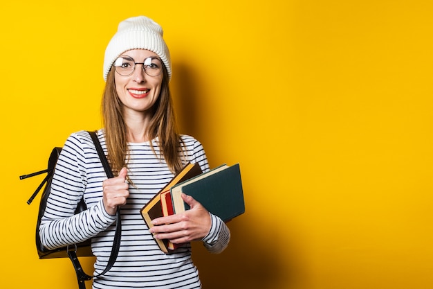 Jovem amigável, lendo um livro sobre um fundo amarelo