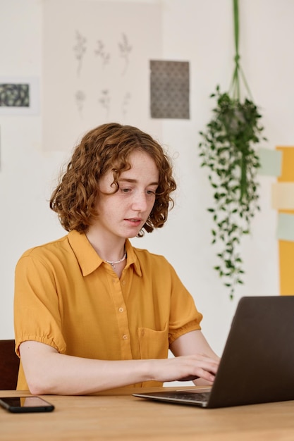 Jovem analista ou gerente em roupas casuais olhando através de dados online