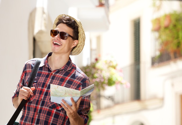 Jovem andando com mapa e bolsa na cidade