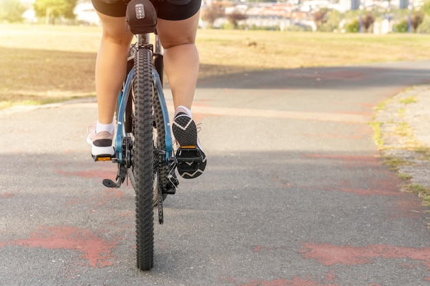 Jovem andando de bicicleta aproveitando um dia ensolarado no parque