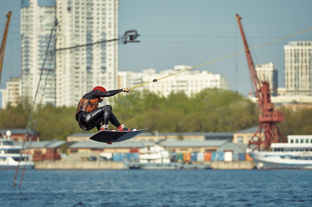 Jovem andando de wakeboard em um lago de verão