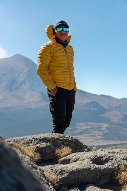 Jovem andando na montanha iztaccihuatl ao amanhecer ao fundo do vulcão popocatepetl