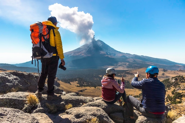 Jovem andando na montanha iztaccihuatl ao amanhecer ao fundo do vulcão popocatepetl