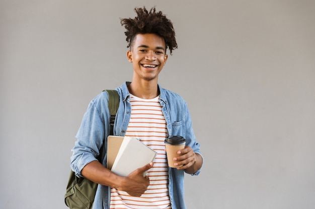 Foto jovem animado caminhando ao ar livre segurando um café