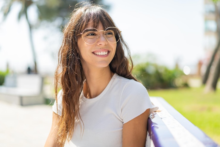 Foto jovem ao ar livre com óculos com expressão feliz