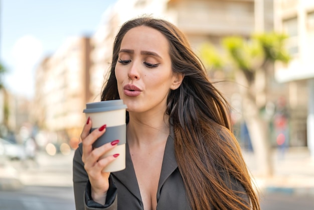 Jovem ao ar livre segurando um café para viagem