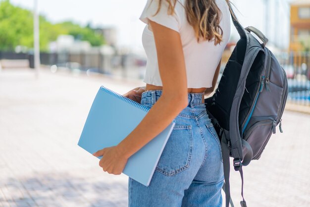 Jovem ao ar livre segurando um notebook