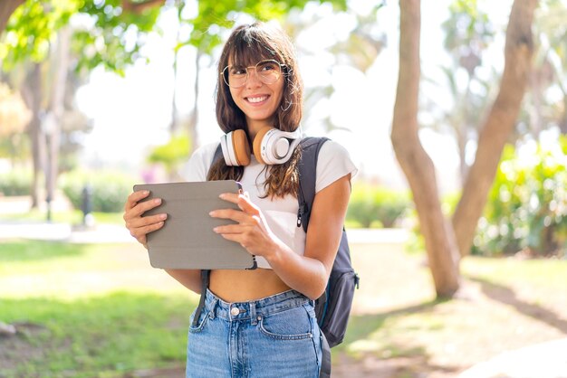 Jovem ao ar livre segurando um tablet