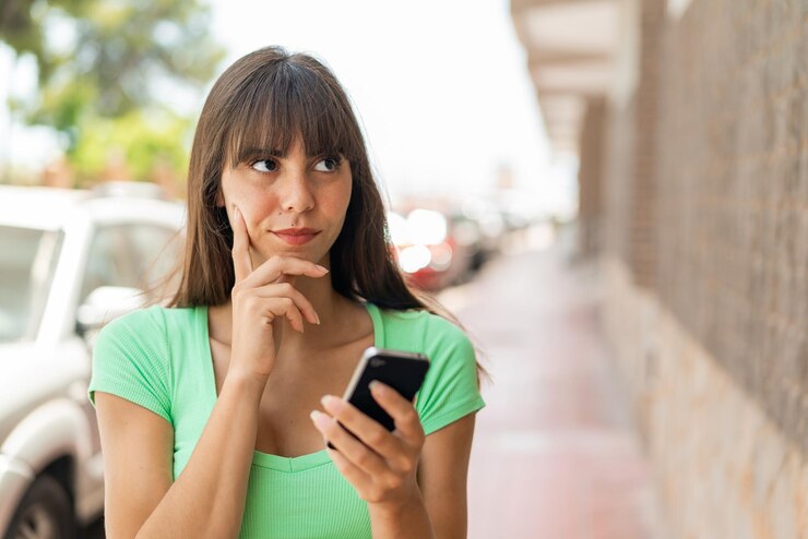 Foto jovem ao ar livre usando telefone celular e pensando