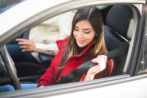 Jovem apertando o cinto de segurança no carro