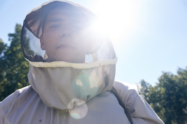 Jovem apiarista na luz solar