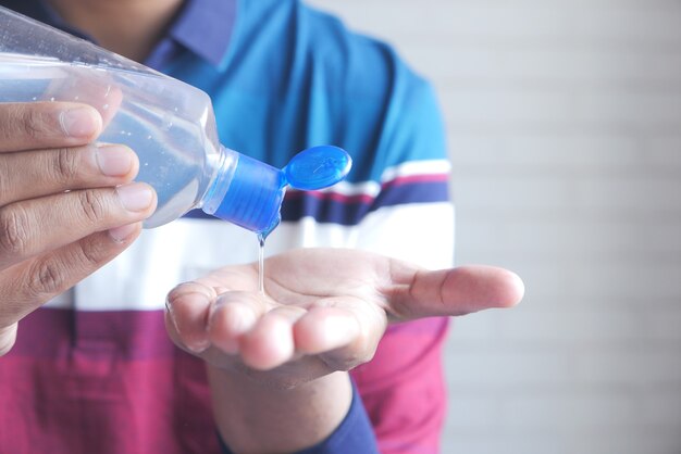 Foto jovem aplicando gel desinfetante para as mãos para prevenir vírus