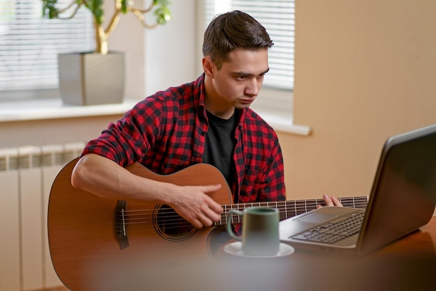 Jovem aprendendo a tocar violão online