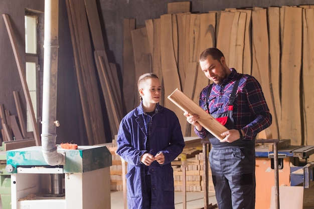 Jovem aprendiz aprendendo a trabalhar na carpintaria