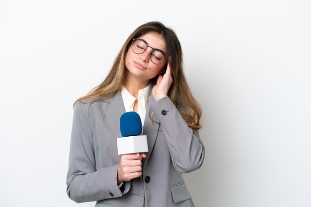 Jovem apresentadora de TV caucasiana isolada em fundo branco com dor de cabeça